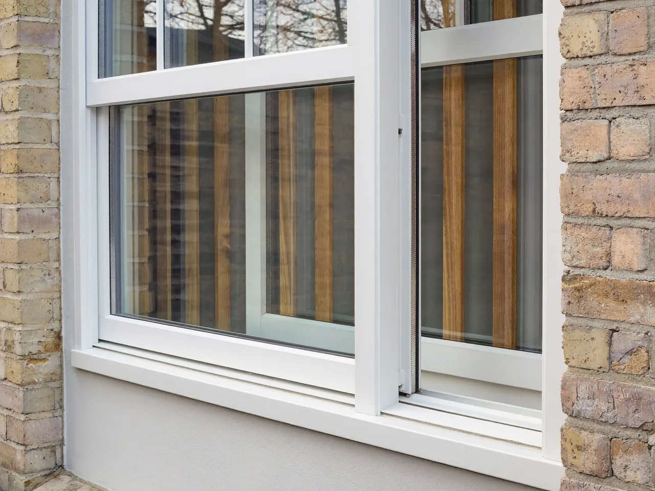 White uPVC sash window fitted in a modern rendered wall
